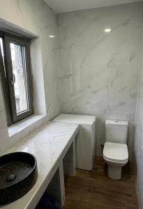 a bathroom with a toilet and a sink and a window at Geamare Studios in Kálamos