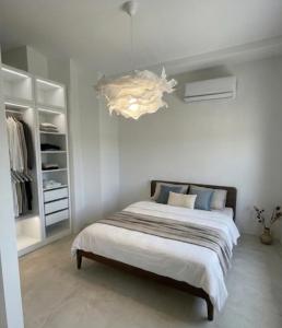 a bedroom with a large bed and a chandelier at Geamare Studios in Kálamos