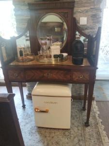 a table with a vanity with a mirror and a cooler at Refúgio no Douro in Nogueira