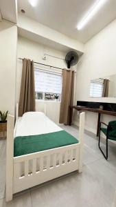 a bedroom with a white bed and a piano at Downtown Hostel Jamaica in Kingston