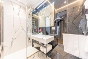 a bathroom with a sink and a shower with a mirror at Charma Luxury Apartment - ROMA in Rome +14 photos