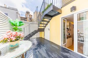 a balcony with a table with flowers on it at Charma Luxury Apartment - ROMA in Rome