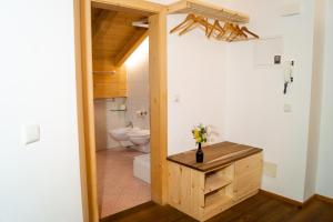a bathroom with a toilet and a wooden table at Ganoihof apartments in Funes +84 photos