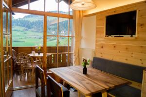 a dining room with a wooden table and a television at Ganoihof apartments in Funes