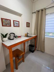 a kitchen with a wooden table and a sink at Downtown Hostel Jamaica in Kingston