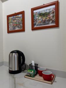 a counter with a coffee pot and cups on a tray at Downtown Hostel Jamaica in Kingston +6 photos