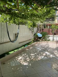 a swing hanging from a fence in a yard at באר מרים in Ashkelon