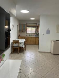 a kitchen with a table and a refrigerator and a table at באר מרים in Ashkelon