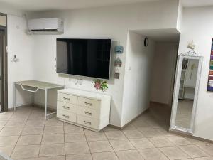 a living room with a flat screen tv on a wall at באר מרים in Ashkelon