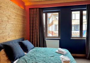 a bedroom with a blue bed and two windows at New Gudauri Studio N207 in Suites! in Gudauri +24 photos