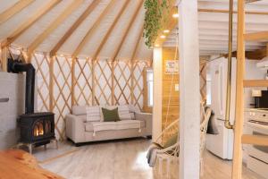 a living room with a couch and a stove in a yurt at Exode en Nature in Sainte-Rose-du-Nord