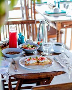 a table with a plate of food and bowls of food at Posada Casa Play Los Roques in El Roque