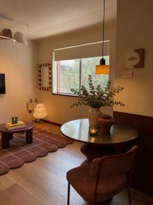 a living room with a table and a window at The Bron Apartment - newly renovated, designer stay in Yarralumla