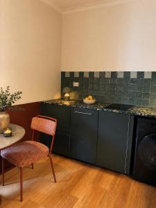 a kitchen with a counter and a chair and a table at The Bron Apartment - newly renovated, designer stay in Yarralumla