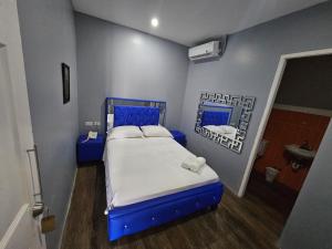 a small bedroom with a blue bed and a sink at Hotel Residencial La Malvarrosa in Panama City +17 photos