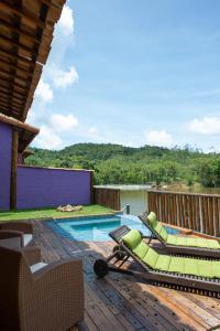 a pool with chaise lounge chairs and a swimming pool at Pousada pegada da onça in Tapiraí