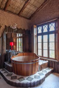 a large wooden tub in a room with windows at Pousada pegada da onça in Tapiraí