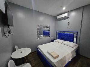 a bedroom with a bed and a table and a tv at Hotel Residencial La Malvarrosa in Panama City