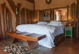 a bedroom with a large bed and a mirror at Pousada pegada da onça in Tapiraí