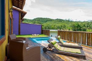 a deck with lounge chairs and a swimming pool at Pousada pegada da onça in Tapiraí