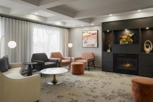 a living room with a fireplace and chairs at Best Western Premier Hotel Aristocrate in Quebec City