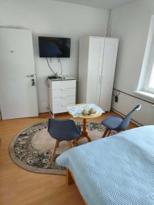 a bedroom with two chairs and a table and a bed at Pokoje gościnne in Międzyzdroje
