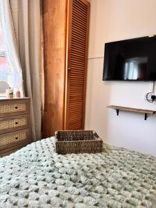 a bedroom with a bed with a television on the wall at The Hidden Gem in Mablethorpe