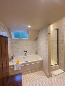 a bathroom with a tub and a sink and a window at Bel And The Dragon-Churt in Farnham +48 photos