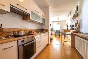 a kitchen with white cabinets and a stove top oven at Sunny Weekend Sauna House - Happy Rentals in Preserje