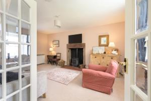 a living room with a fireplace and a red chair at Cardross Holiday Cottages in Arnprior