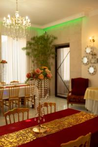 a dining room with a table with a vase of flowers at Hotel and Restaurant "VILLA GIVISI" in Lagodekhi