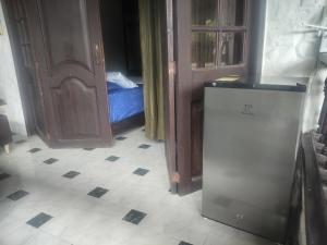 a room with a refrigerator and a door and a floor at HOSPEDAJE TURÍSTICO CAMPESTRE "VILLA ALONDRA" Parqueo Privado! in Villavicencio