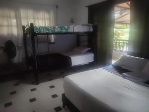 a bedroom with two bunk beds and a window at HOSPEDAJE TURÍSTICO CAMPESTRE "VILLA ALONDRA" Parqueo Privado! in Villavicencio