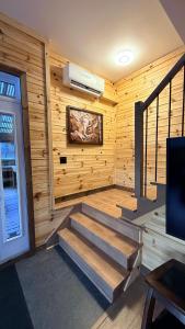 a room with wooden walls and stairs in a house at Le Shack du Nord in Mont-Laurier