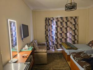 a small living room with a bed and a tv at La sirena double room with mountain view, Families and couples only, Extra of 180 Egyptian pounds per adult person per stay ,to be paid to the resort in Ain Sokhna +37 photos