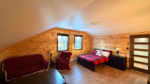 a bedroom with a bed and a couch in a room at Le Shack du Nord in Mont-Laurier