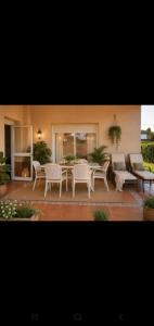 a patio with a table and chairs and a couch at Hogar Leticia in Seville