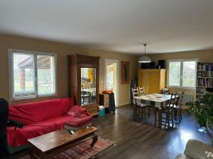 a living room with a red couch and a table at Chambre à louer dans villa ou Location maison entière in Montjoux