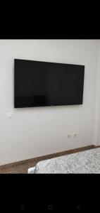 a flat screen tv on a white wall at Hogar Leticia in Seville