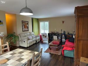 a living room with a couch and a table at Chambre à louer dans villa ou Location maison entière in Montjoux