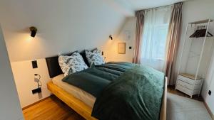 a bedroom with a bed with a green blanket at Klimatisierte Komfort-Eifel-Ferienwohnung Mechernich, Obergartzem, Satzvey - nahe Krewelshof, Burg Satzvey & Phantasialand in Mechernich