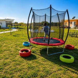 a boy is playing on a trampoline at Agroktima Arta - Farm Stay in Arta