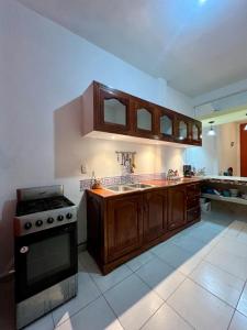 a kitchen with wooden cabinets and a stove top oven at La casa de los Faroles in Cuetzalán del Progreso