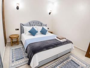 a bedroom with a large bed with blue pillows at Cosy in Marrakesh