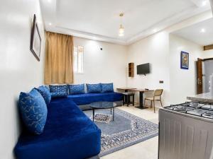a living room with a blue couch and a table at Cosy in Marrakesh