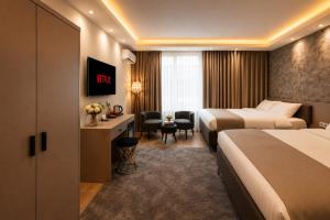 a hotel room with two beds and a desk at Huzur Apart Hotel in Istanbul