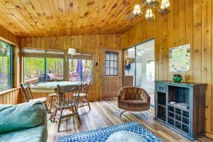 a living room with a fireplace and a table and chairs at Peaceful Wooded Retreat at Lake Wallenpaupack! in Lake Ariel
