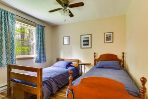 two beds in a bedroom with a ceiling fan at Peaceful Wooded Retreat at Lake Wallenpaupack! in Lake Ariel +30 photos