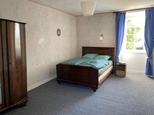 a bedroom with a bed and a window with blue curtains at Kerannie in Lanvollon