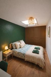 a bedroom with a bed and a green wall at Maison de rue: Auch in Auch